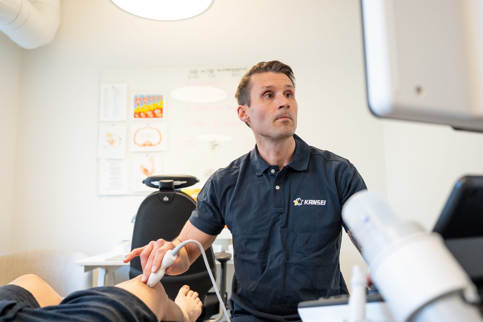 Carl-Robert Kårell undersöker ett knä med ultraljud på kliniken
